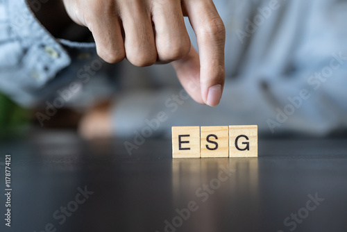 ESG concept. Business man hand holding wooden cube words ESG on a wood block