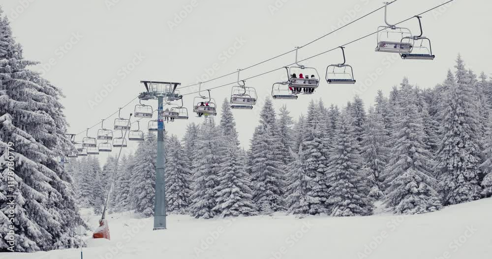 Ski lift ascending over a snowy alpine forest during a peaceful winter snowfall at Kopaonik resort Ski lift ascending over a snowy alpine forest during a peaceful winter snowfall at Kopaonik resort