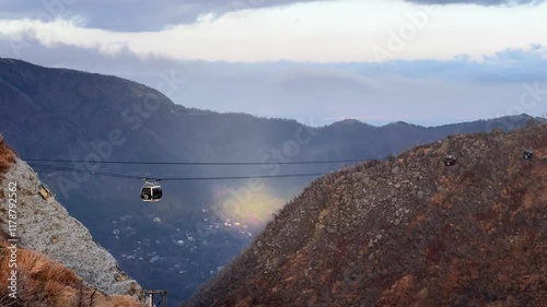 A cable car gliding over scenic Owakudani Hakone mountains with cloudy skies