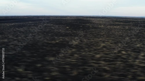 4K aerial POV Drone flying over the agricultural field from the side