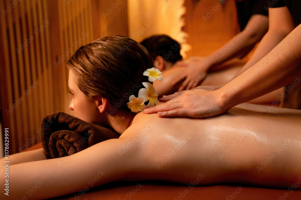 Obraz premium Caucasian couple customer enjoying relaxing anti-stress spa massage and pampering with beauty skin recreation leisure in warm candle lighting ambient salon spa at luxury resort or hotel. Quiescent