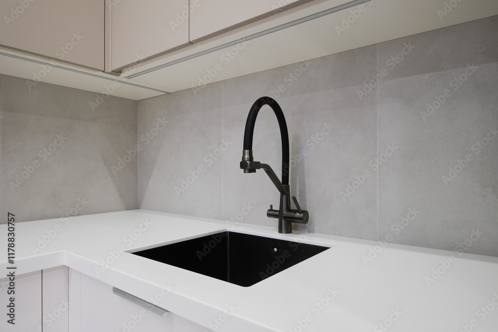 Modern kitchen sink setup in minimalist design with sleek faucet and dark basin Modern kitchen sink setup in minimalist design with sleek faucet and dark basin