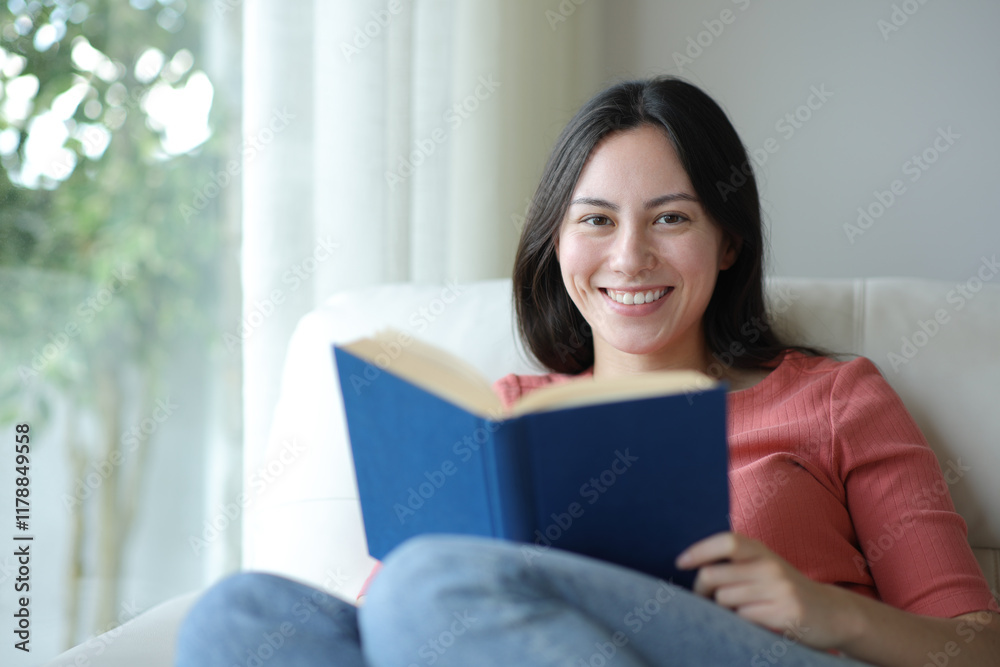 Happy asian woman holding paper book looking at you Happy asian woman holding paper book looking at you