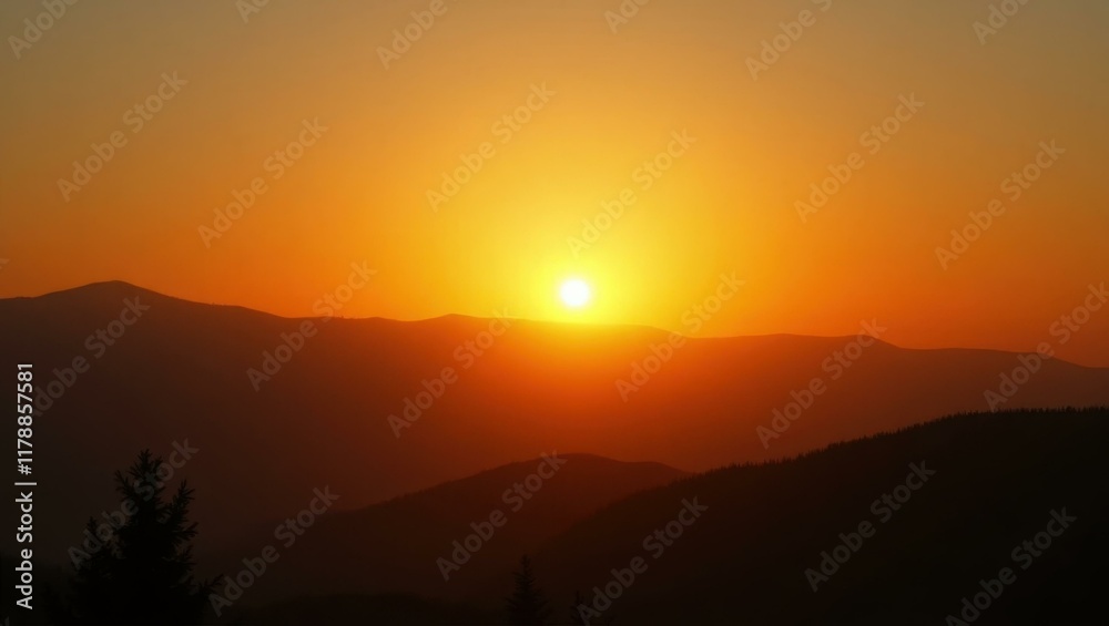 Fototapeta premium Golden sun setting behind dark mountain silhouettes, peaceful nature landscape during warm evening, perfect for relaxation, travel, adventure, or inspirational backgrounds with orange sky glow