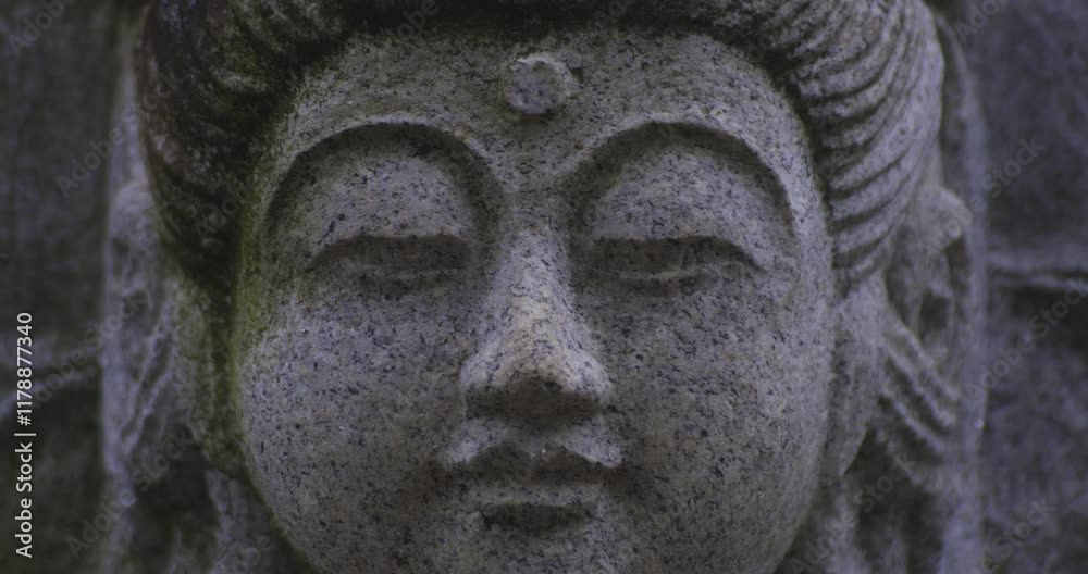 A religious stone statue of Kannon at Japanese buddhism temple A religious stone statue of Kannon at Japanese buddhism temple