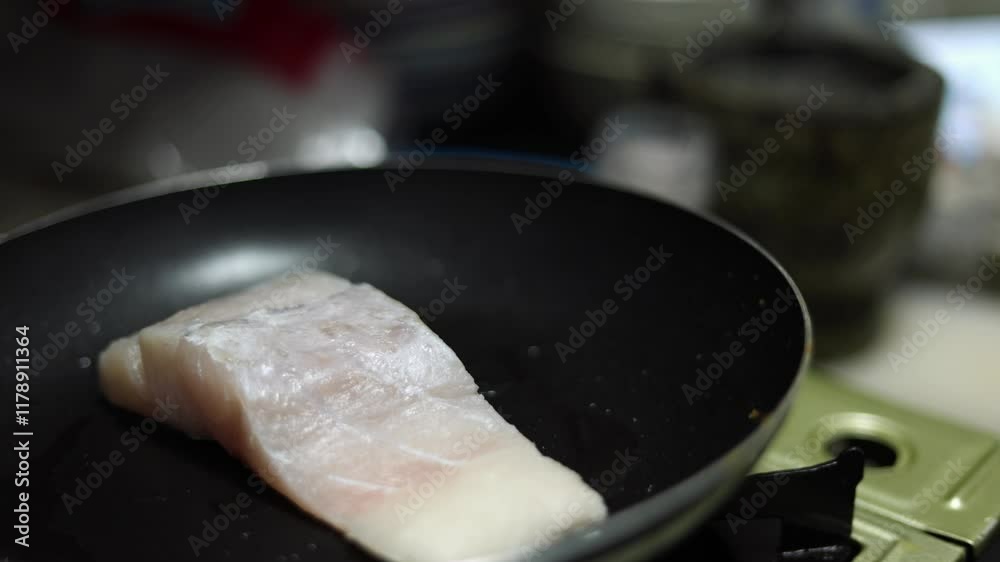 Fried sea bass fillet, cooking grilled fish steak in a pan Fried sea bass fillet, cooking grilled fish steak in a pan
