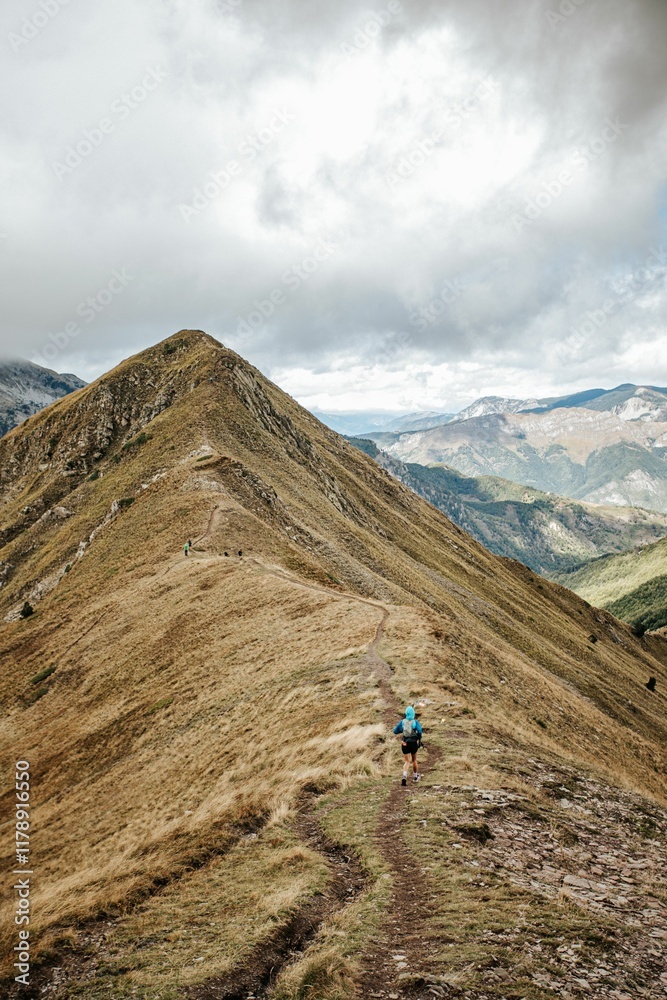 Hiker on a scenic mountain ridge trail. Hiker on a scenic mountain ridge trail.