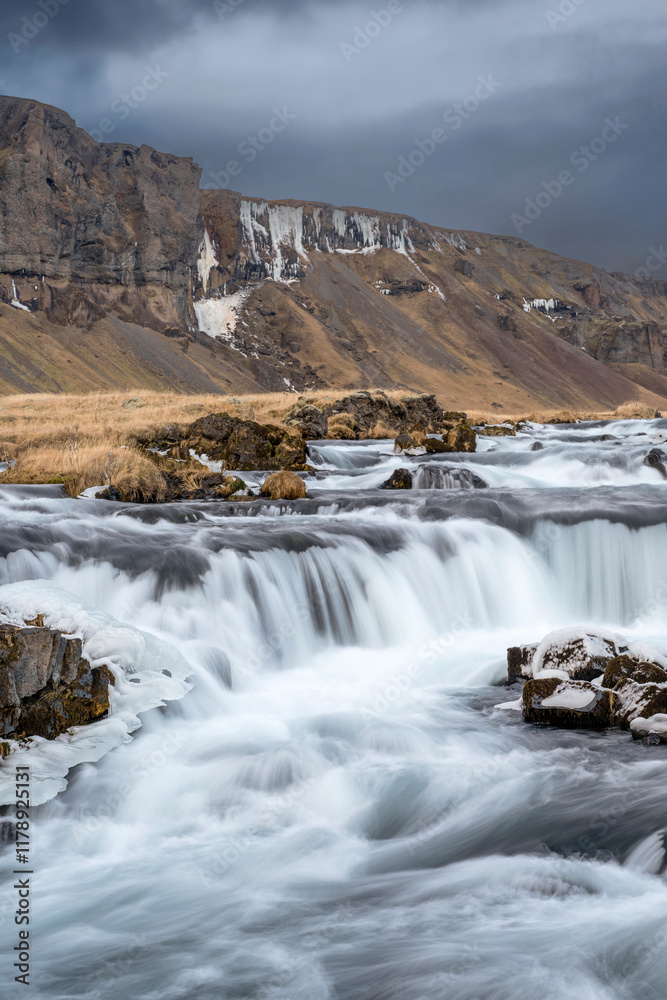 Fototapeta premium Panoramic view of the cliff and flowing rushing water on the river in Kirkjubæjarklaustur or Kirkjubaejarklaustur, Iceland