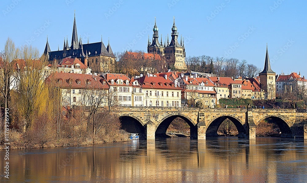 Naklejka premium Prague cityscape with Vltava River, bridge, St. Vitus Cathedral, and historic buildings.