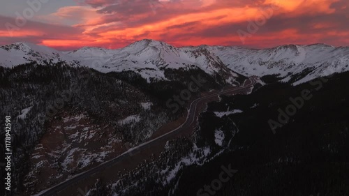 Rocky Mountains aerial drone i70 highway Winter solstice Colorado vibrant orange red cloudy skies setting sunset cars trucks traffic Coon Hill Parshall Eisenhower tunnel Continental Divide forward pan