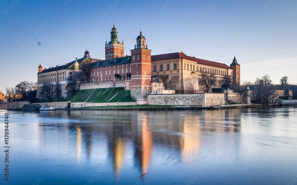 Fototapeta premium Krakow's Wawel Castle, Poland Majestic castle reflected in calm river at sunrise.