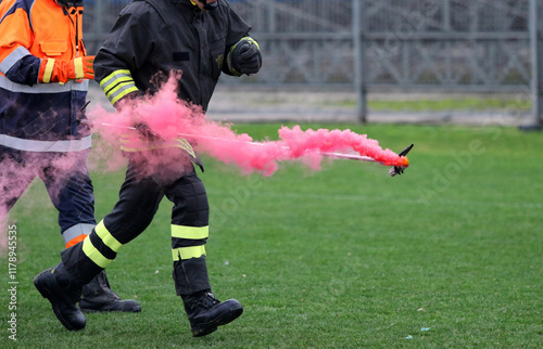 Italian Firefighter removes a smoke bomb thrown from the stands by fans of a team at the Stadium. Italy