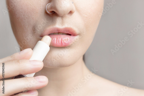 Woman with dry lips, Dry, chapped, dry skin problem with mouth disease, A woman applies a moisturizing lip balm. close up