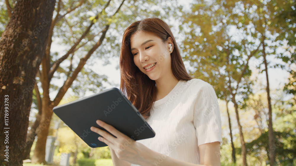 Asian Woman Working Remotely in a Park, Using Tablet for Hybrid Work Lifestyle, Tranquil Freelance, Joyful Digital Nomad in Nature, Relaxing and Working in Nature, Remote work using Tablet in greenery Asian Woman Working Remotely in a Park, Using Tablet for Hybrid Work Lifestyle, Tranquil Freelance, Joyful Digital Nomad in Nature, Relaxing and Working in Nature, Remote work using Tablet in greenery