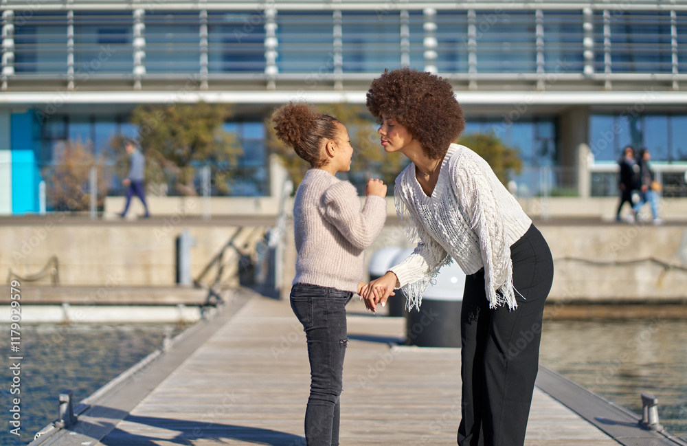 Fototapeta premium Mother and daughter sharing a tender moment on a pier
