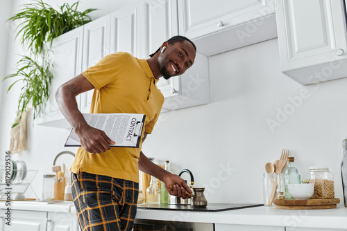 Young man enjoys remote work in a stylish kitchen while brewing coffee photo