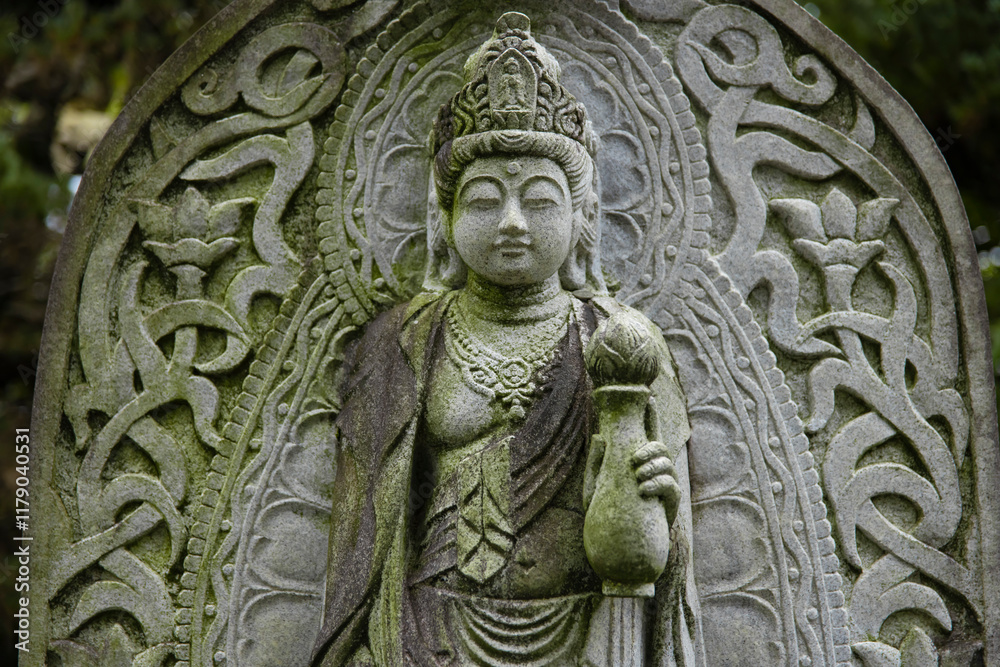 A religious stone statue of Kannon at Japanese buddhism temple A religious stone statue of Kannon at Japanese buddhism temple