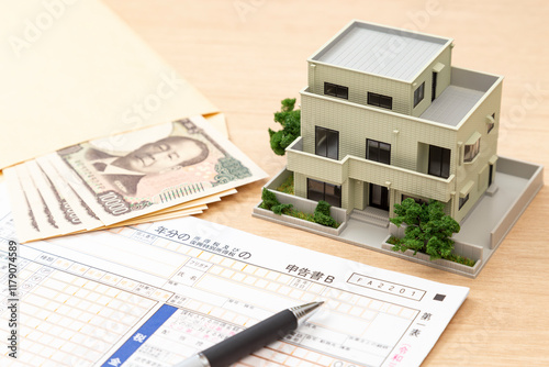 机に置かれた確定申告書類と住宅模型 photo