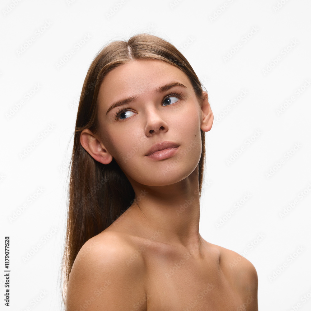 Portrait of young attractive woman, with bare shoulders, looking away show her perfect smooth skin against white studio background. Concept of natural beauty, self care, dermatology. Ad Portrait of young attractive woman, with bare shoulders, looking away show her perfect smooth skin against white studio background. Concept of natural beauty, self care, dermatology. Ad