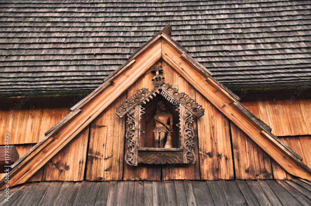 Wooden figure above the entrance to the wooden historic church in Dębno