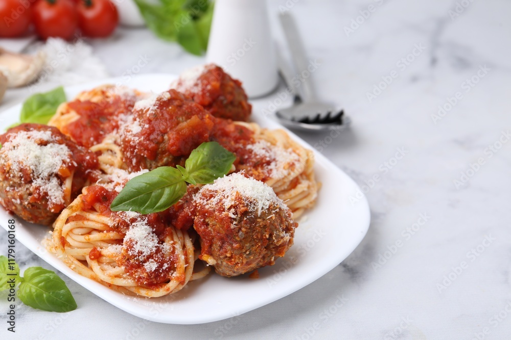 Delicious pasta with meatballs, basil and cheese on white table, closeup. Space for text Delicious pasta with meatballs, basil and cheese on white table, closeup. Space for text