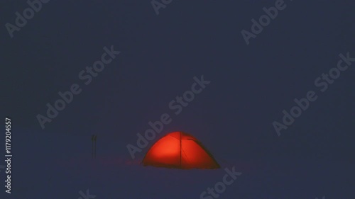 A glowing tent at night with a red light surrounded by darkness. The light gradually fades, creating a serene and mysterious atmosphere.