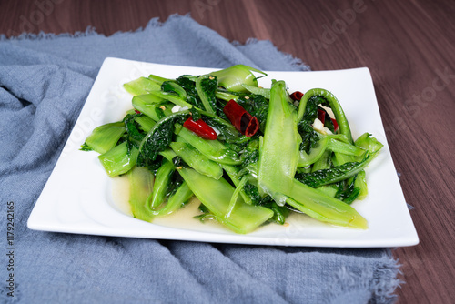 Stir-fried vegetable lettuce tips on a white plate photo