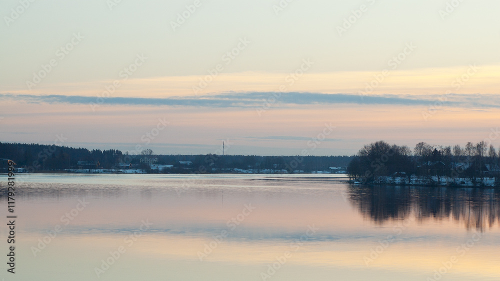 Obraz premium The photo shows a sunset on the river in winter