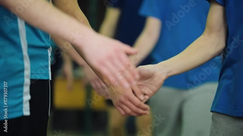 Volleyball players shake hands under the net before the start of a match. A moment of sports etiquette, friendliness and team spirit.