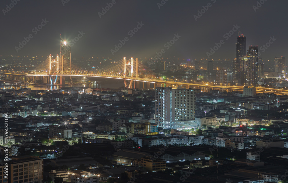 Nightscape view of Skyscrapers with Thotsamarachan Bridge (Rama IX Bridge) crossing Chao phraya river. Beautiful city of Bangkok with bright glowing lights, use it as your Wallpaper, Poster and Space.