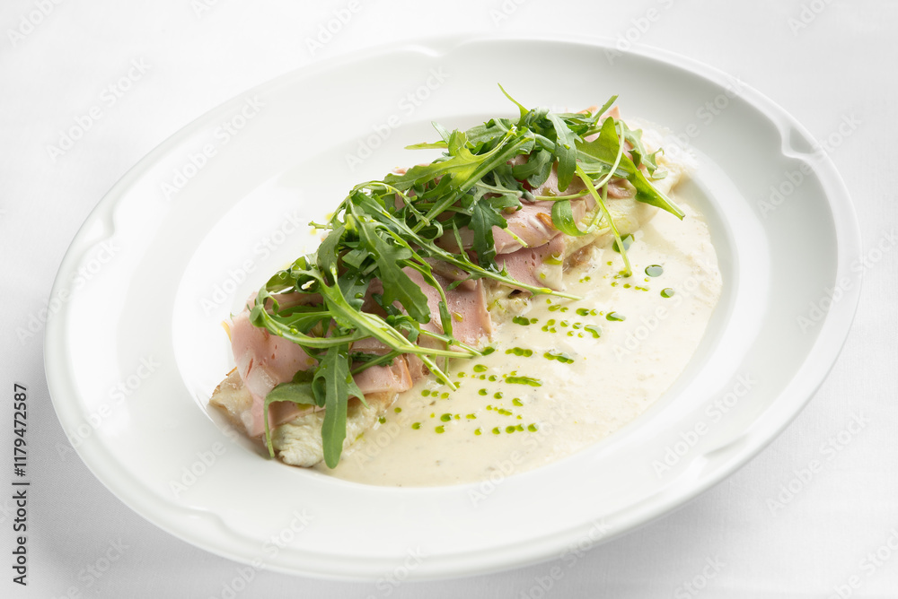 A gourmet dish featuring omelet topped with ham and fresh arugula, accompanied by a creamy sauce. Ideal for culinary and restaurant promotional materials. A gourmet dish featuring omelet topped with ham and fresh arugula, accompanied by a creamy sauce. Ideal for culinary and restaurant promotional materials.