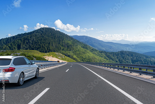 Obraz na płótnie The car is driving along the highway surrounded by picturesque nature. w salonie