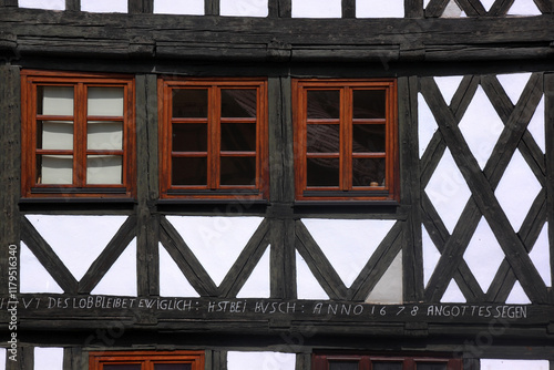 Architectural detail of a half-timbered facade with windows on a residential house in the old medieval town of Halberstadt, Germany photo