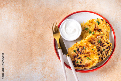 Vegetarian comfort food, potato pancakes. Traditional european vegetable dish, potato fritters, cutlets, latkes (flapjacks, hash brown or potato vada) with sour cream photo