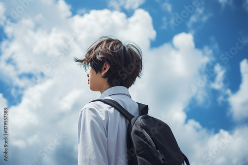 空を見上げる男子高生の後ろ姿
