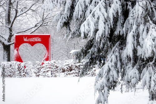 rotes Herz mit Schriftzug im verschneiten Park