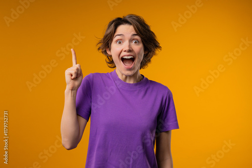 Breakthrough genius idea. Happy woman having eureka moment, pointing finger up on yellow background. Clever lady showing answer gesture or remembered what she forgot, memory concept