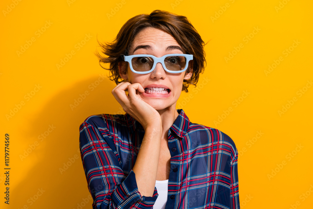 Fototapeta premium Portrait of frightened girl wear checkered shirt in 3d glasses watch horror movie biting fingers isolated on yellow color background
