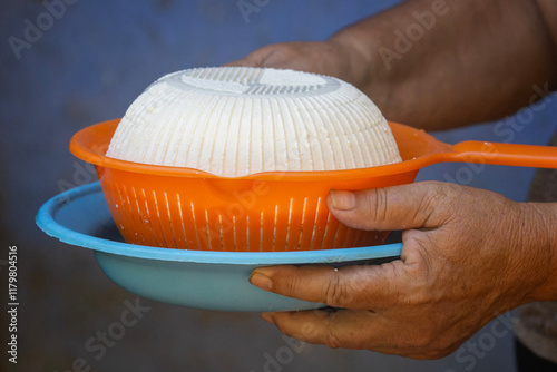 Queso Fresco en un Colador Naranja Sosteniéndose Sobre un Plato Azul