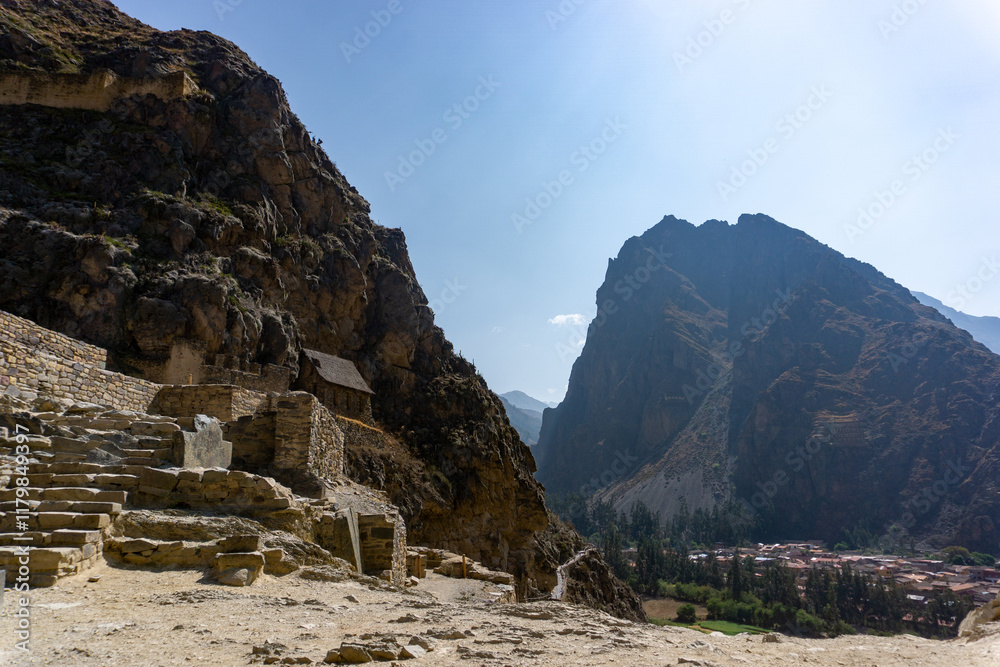 Naklejka premium Ancient Inca archaeological park of Ollantaytambo with stone terraces and a backdrop of Andean peaks in Peru