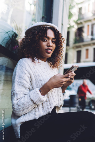 Thoughtful African American woman messaging on smartphone photo