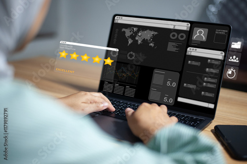 Young businesswoman interacts with a laptop displaying a dark interface with data visuals, ratings, and user profiles, suggesting data analysis or online evaluation. Satisfaction concept.