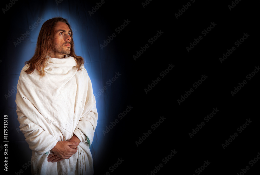 Handsome, religious, spiritual man in a white robe on a black background