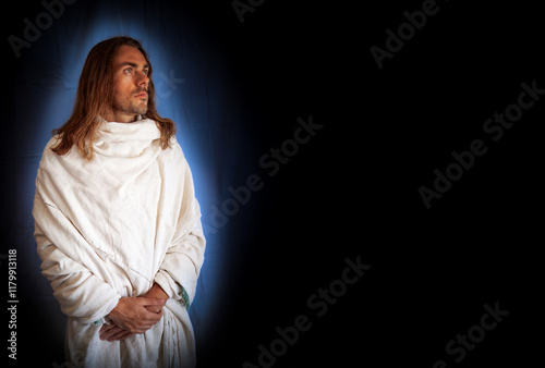 Obraz na płótnie Handsome, religious, spiritual man in a white robe on a black background w salonie