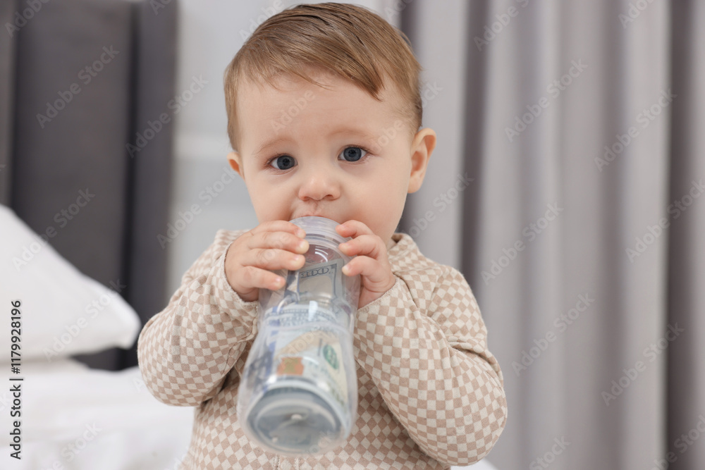 Cute little baby with money in bottle at home Cute little baby with money in bottle at home