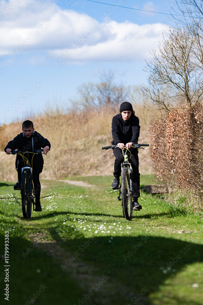 Two young people ride mountain bikes along a rural path, bathed in sunlight. The scene is peaceful and evokes a sense of freedom and outdoor adventure. Two young people ride mountain bikes along a rural path, bathed in sunlight. The scene is peaceful and evokes a sense of freedom and outdoor adventure.