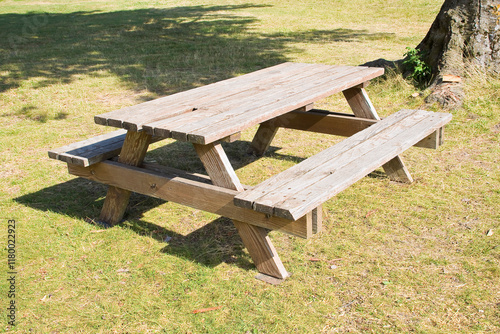 EMPTY WOODEN PICNIC TABLE WITH BENCHES on a green meadow in a pu photo