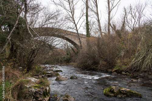 Puente medieval y paisaje invernal sobre un río en Pradillo, La Rioja, España. photo