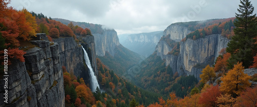 Majestic waterfall cascading through a vibrant autumn valley surrounded by towering cliffs and misty mountains, evoking a sense of awe in nature's beauty photo