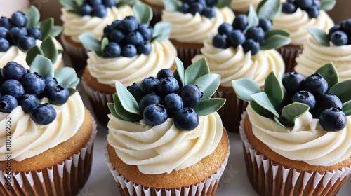 Eucalyptus and Blueberry Cupcakes: A photo of cupcakes with plump blueberries on top and creamy white frosting, decorated with greenery for an elegant winter wedding theme photo